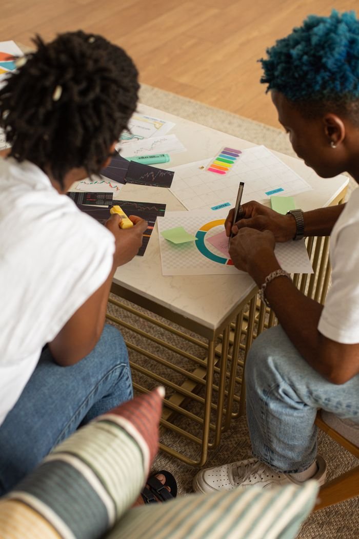 Two adults collaborating on a colorful design project, focused on teamwork and creativity.